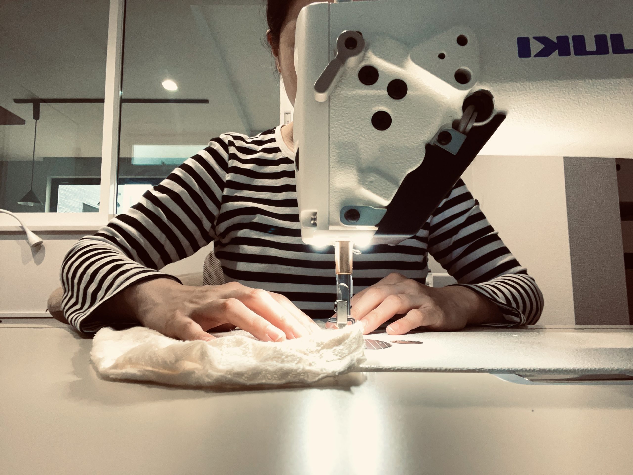 ミシンを使って縫う女性